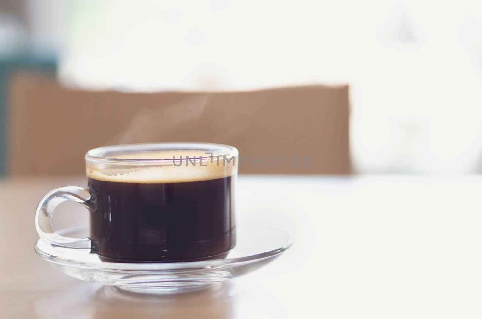 Closeup glass of hot americano coffee on wood table with smoke,  by pt.pongsak@gmail.com