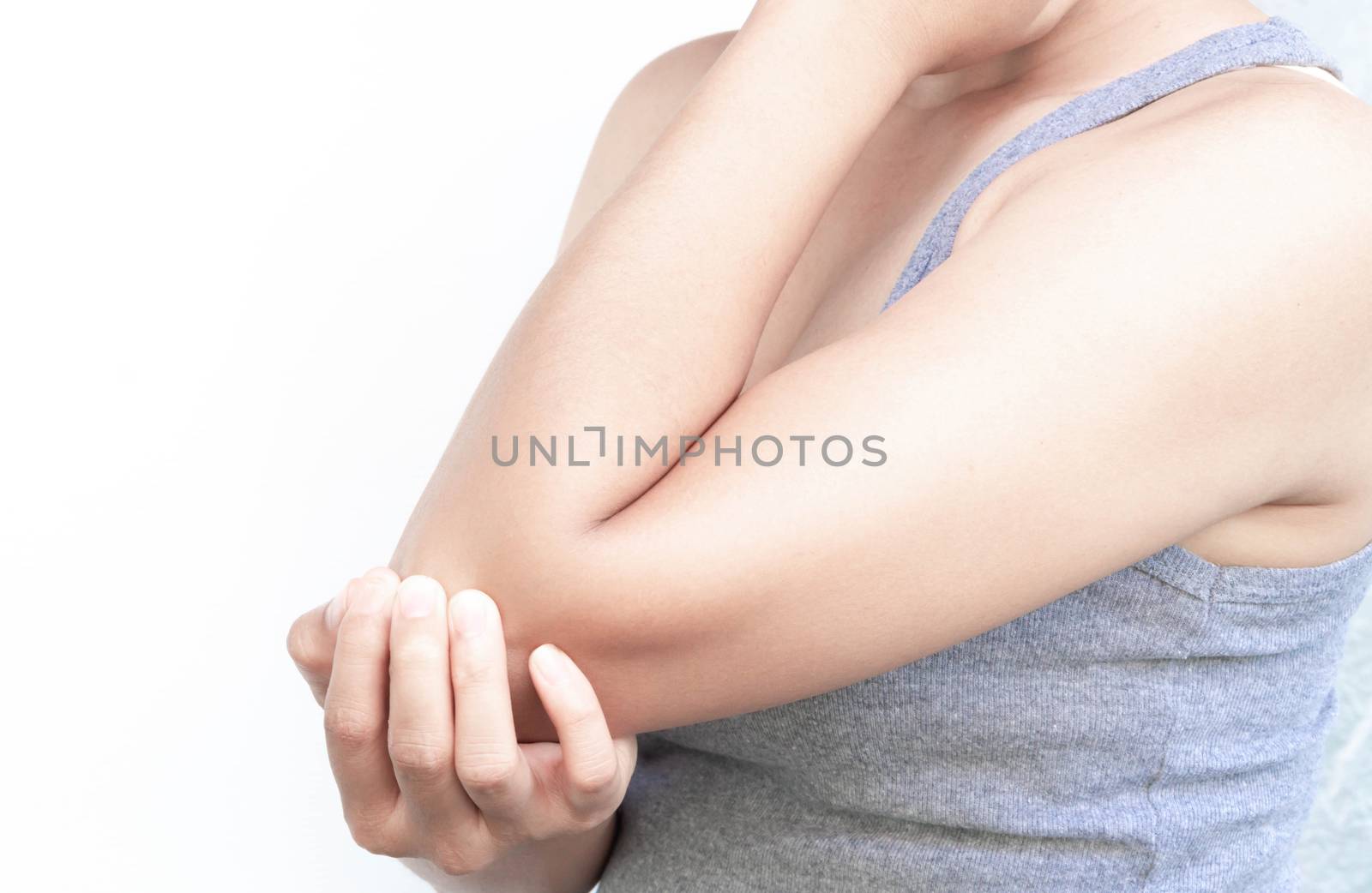 Closeup woman hand holding elbow with pain on white background,  by pt.pongsak@gmail.com