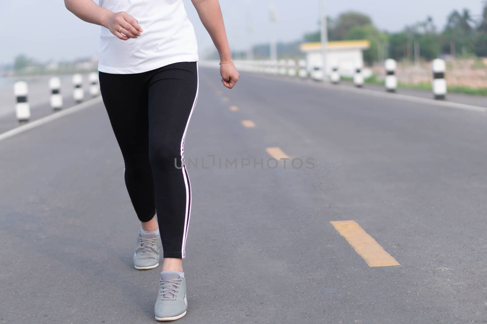 Close up woman legs running on the road at morning, selective fo by pt.pongsak@gmail.com