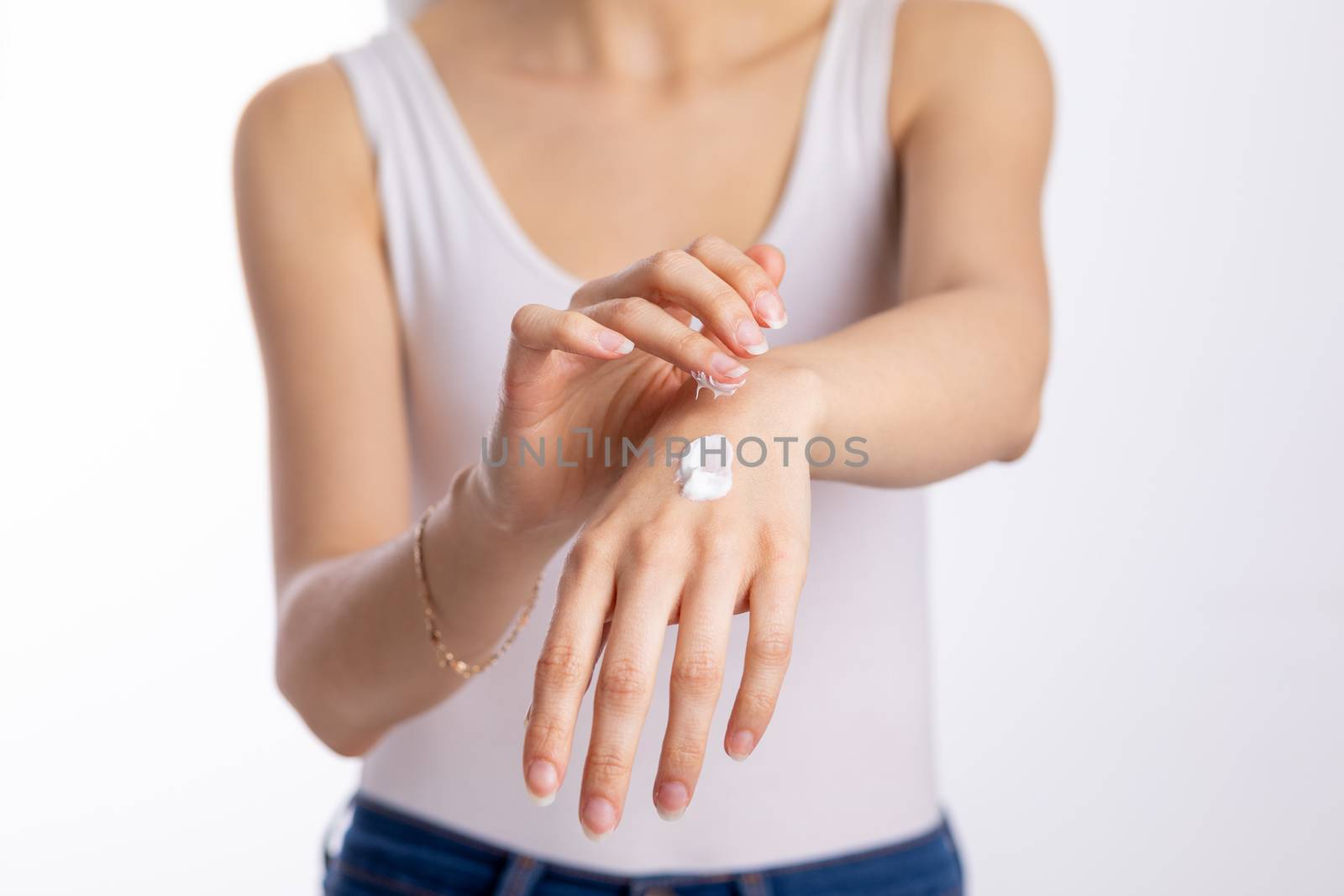 Young woman applying hand cream to protect and care skin, close up.