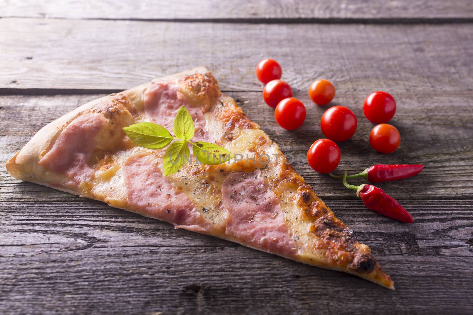 Italian food - pizza on wooden table. Cherry tomato and hot peppers