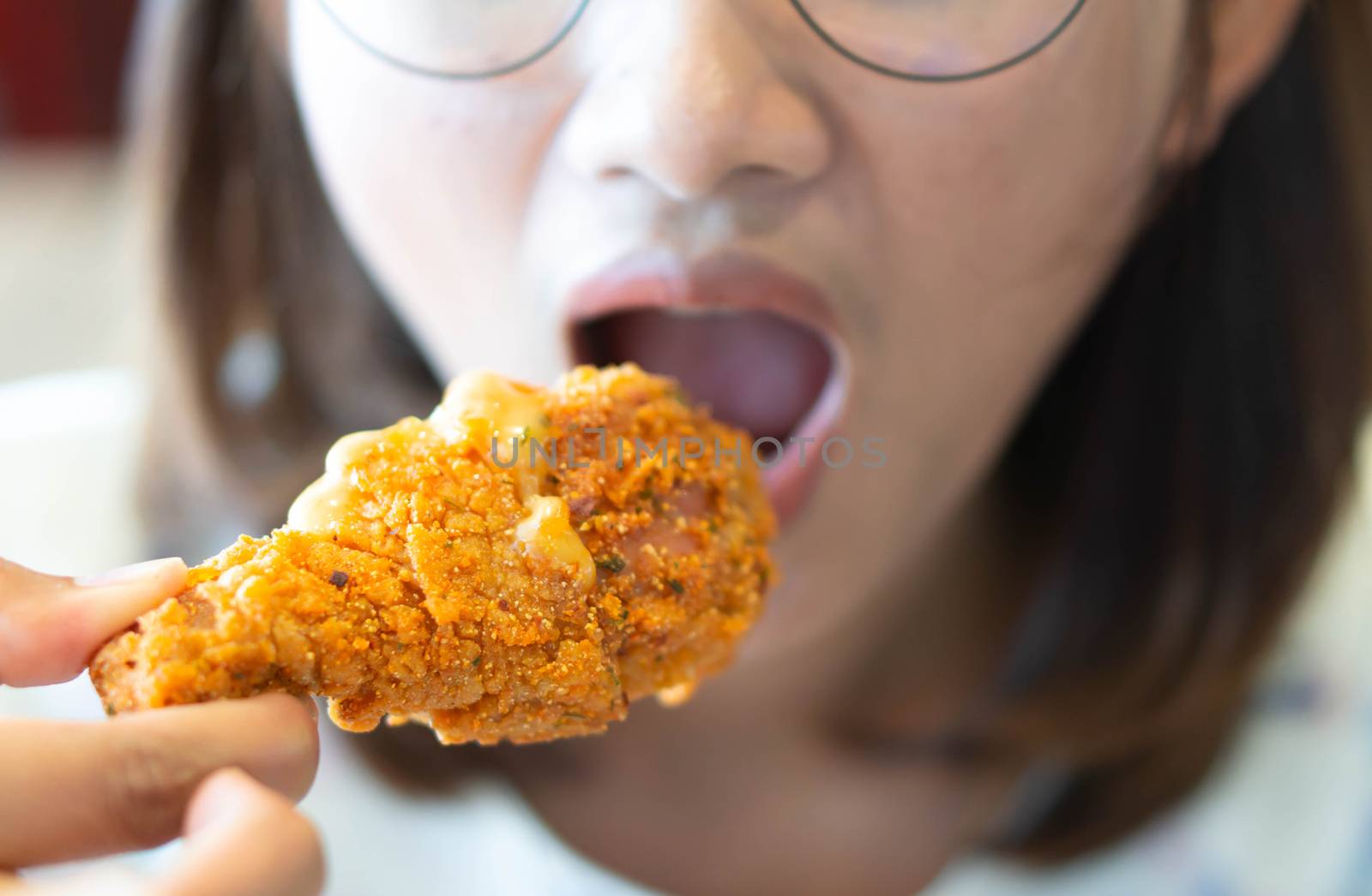 Close up woman eating fried chicken legs, selective focus by pt.pongsak@gmail.com