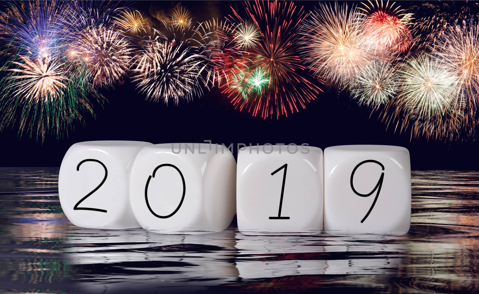 Multiple firework explosions against dark blue sky with calendar date and water reflections for 2019 New Years celebrations