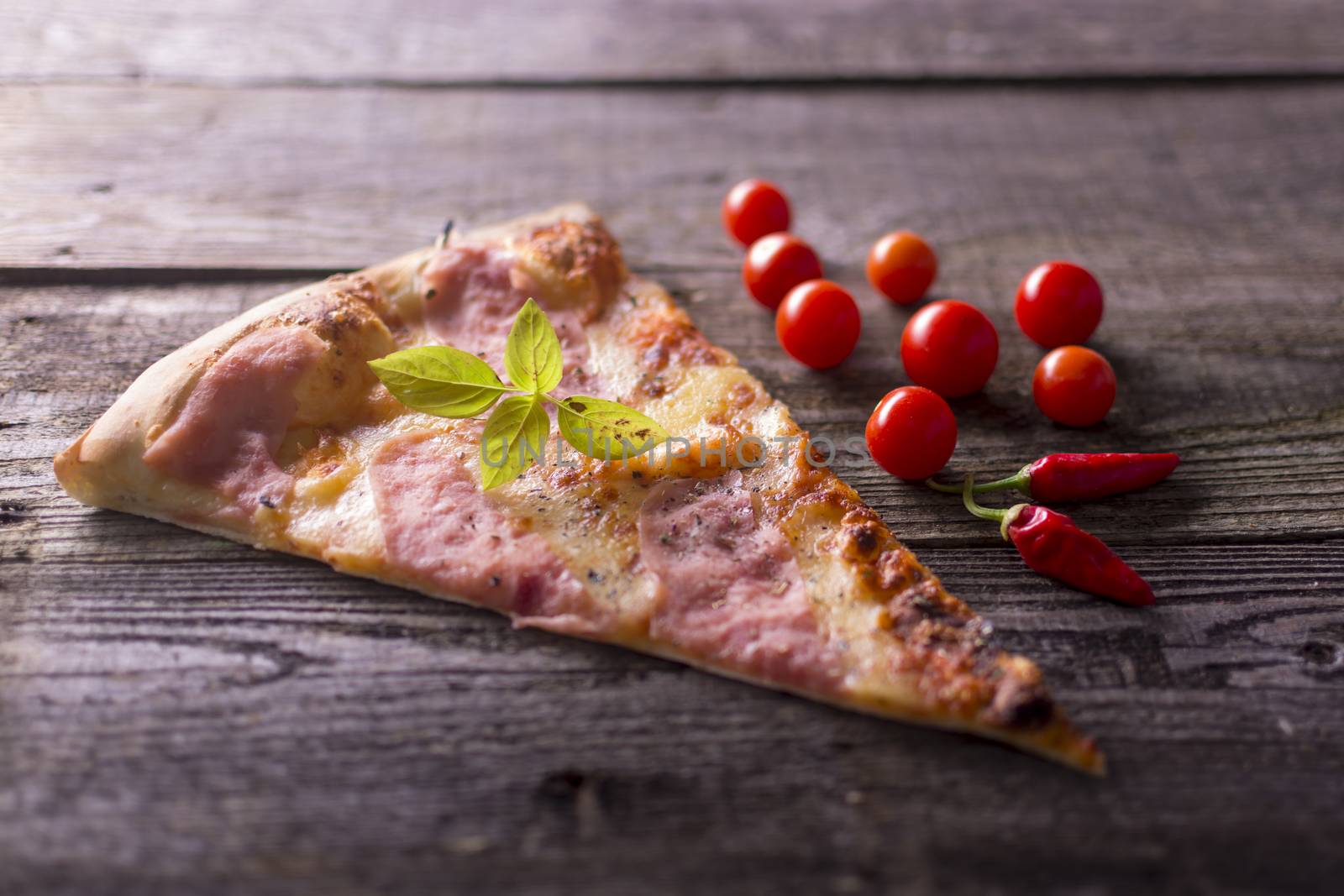 Italian food - pizza on wooden table. Cherry tomato and hot peppers