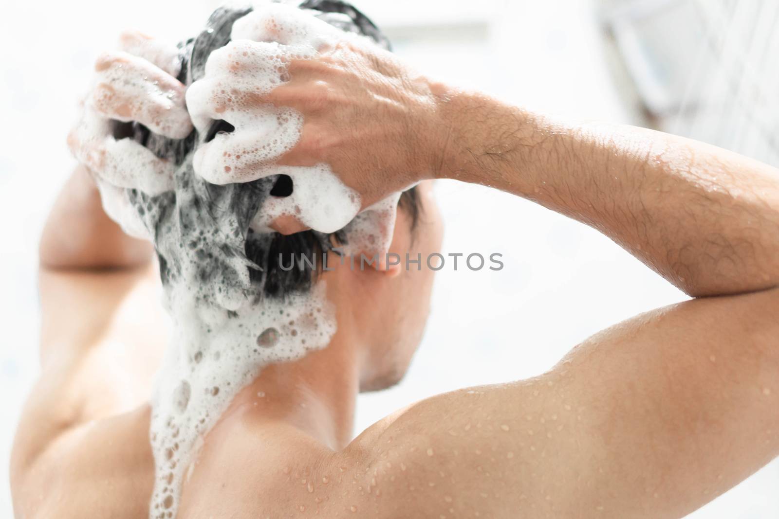 Closeup young man washing hair with with shampoo in the bathroom by pt.pongsak@gmail.com