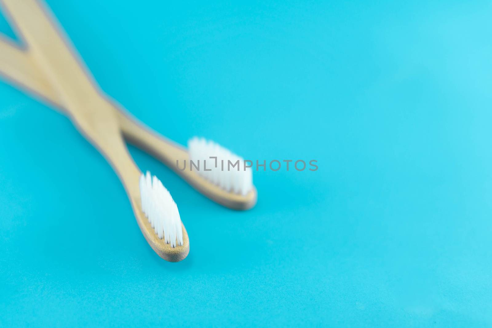 Close up wooden toothbrush on blue background, selective focus by pt.pongsak@gmail.com