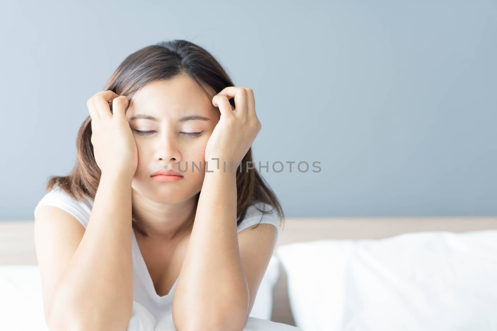 Closeup woman sitting on bed in the bedroom with depressed feeling, selective focus