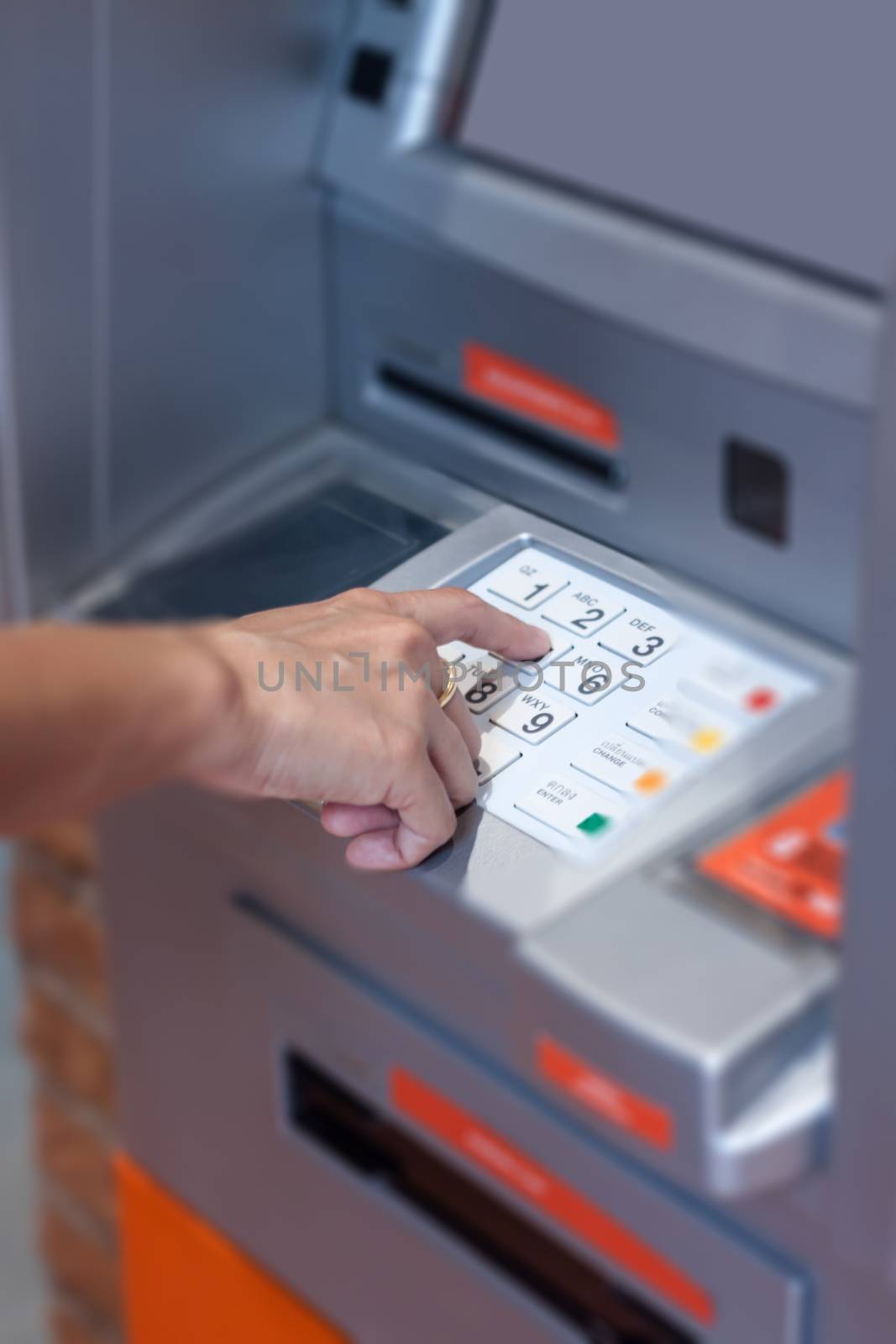 Close up of hand entering pin code at Automated Teller Machine by punsayaporn