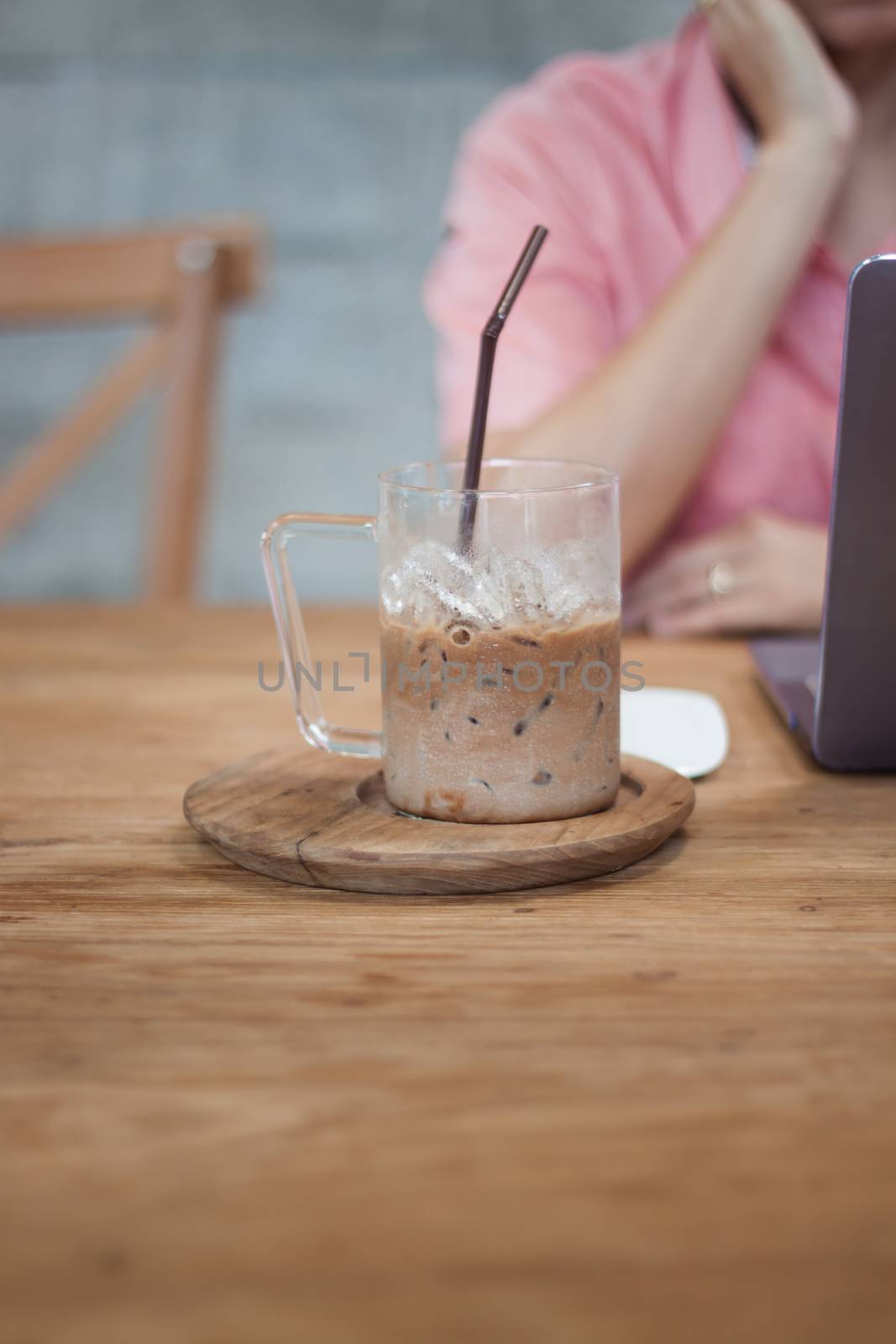 Woman working on computer in coffee shop, stock photo