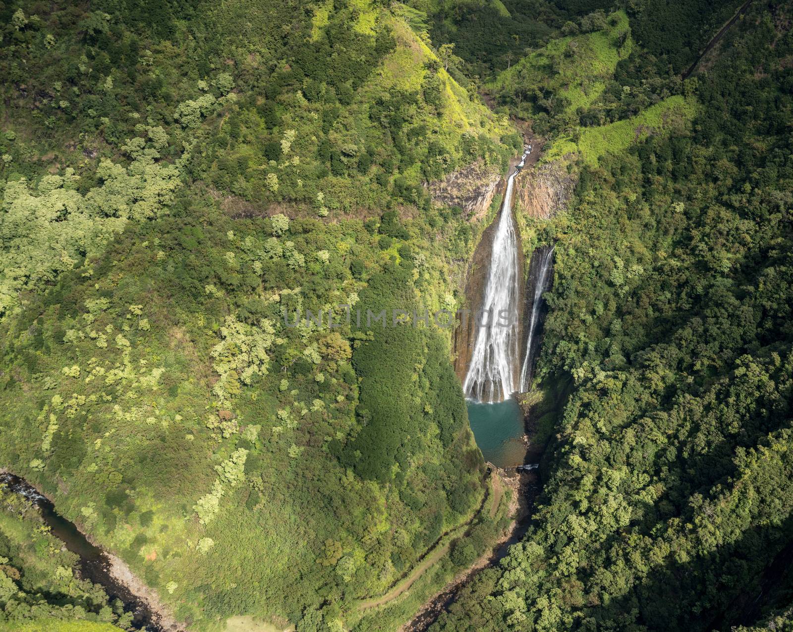 Aerial view of Manawaiopuna Falls and landscape of hawaiian island of Kauai from helicopter flight