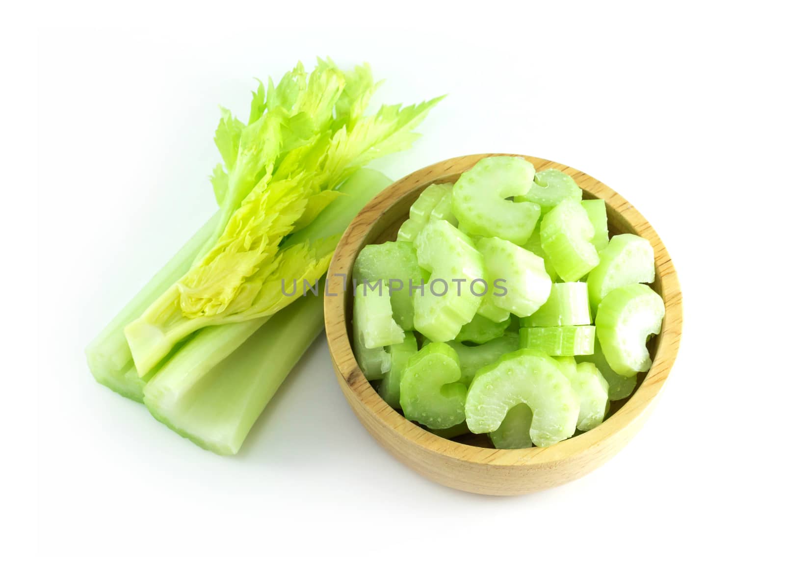 Fresh celery vegetable in wood bowl and sliced  isolated on whit by pt.pongsak@gmail.com