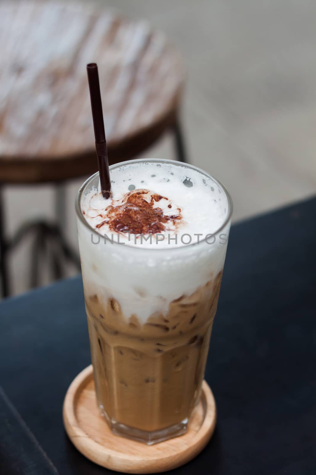 Ice coffee on wooden table by punsayaporn