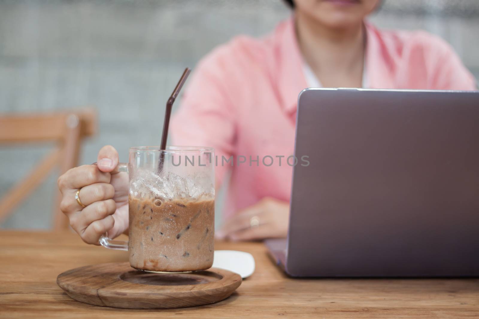 Woman working on computer in coffee shop by punsayaporn