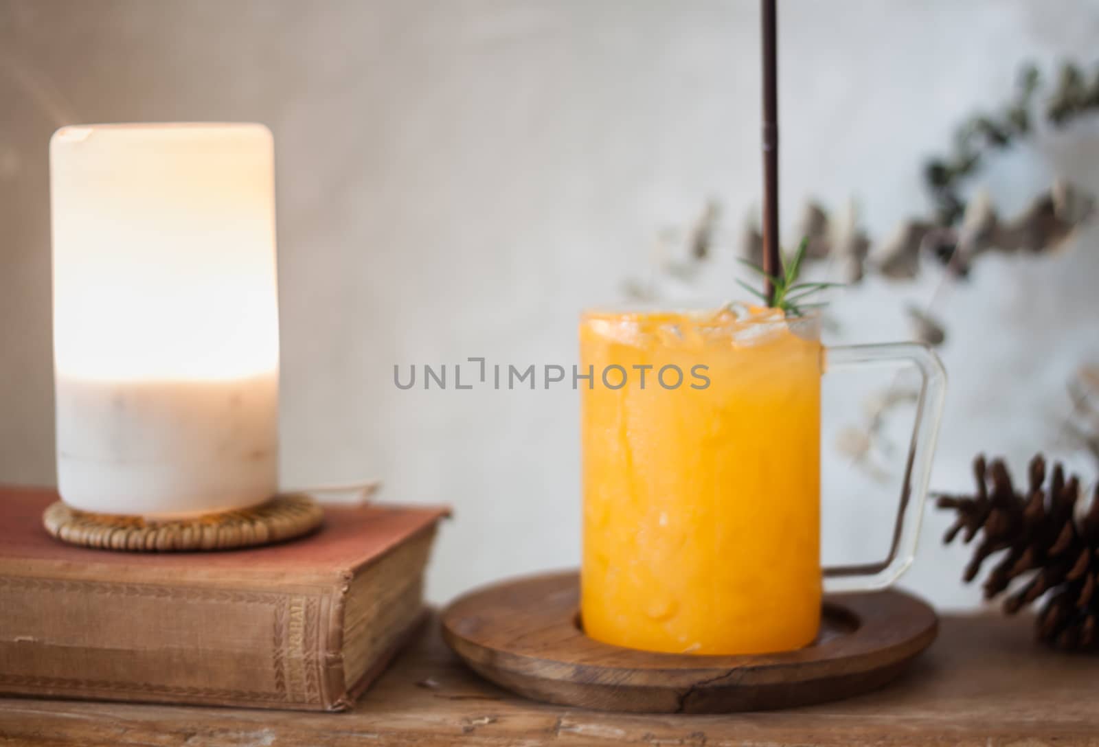 Glass of fresh orange juice with slice on wooden table