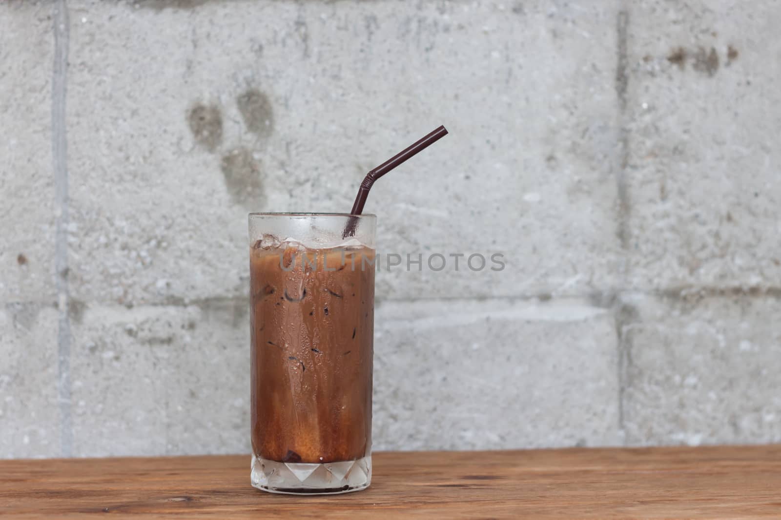 Ice coffee on wooden table by punsayaporn