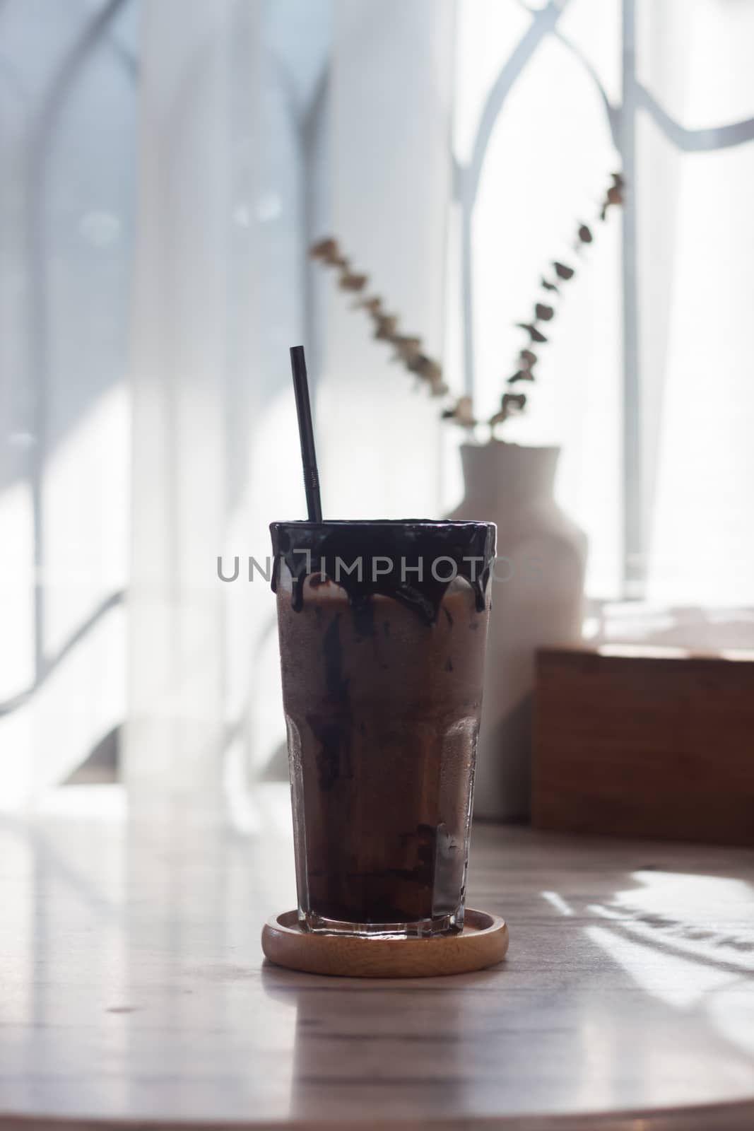 Ice coffee on wooden table by punsayaporn