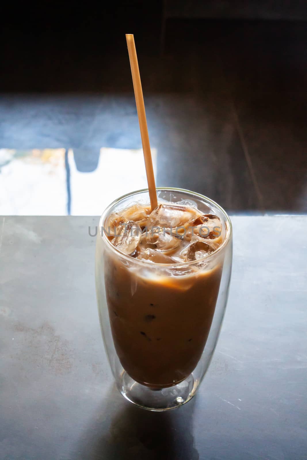 Iced coffee in coffee shop on wooden table by punsayaporn