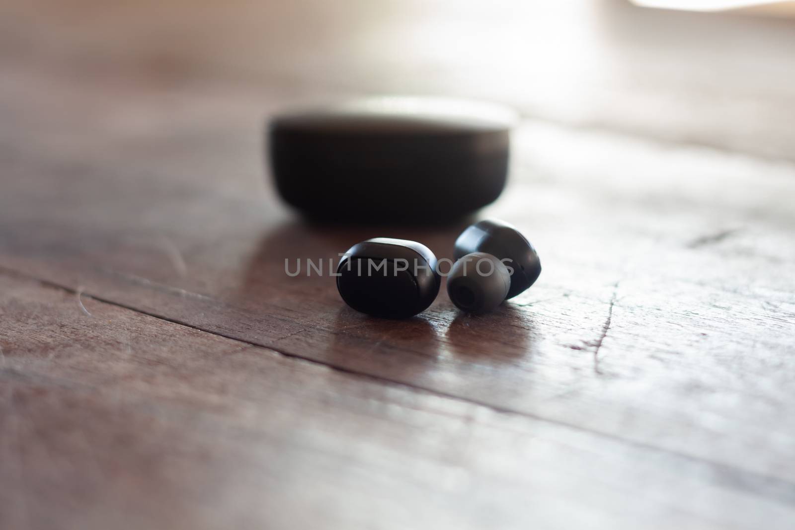 Wireless headphones on wooden background by punsayaporn