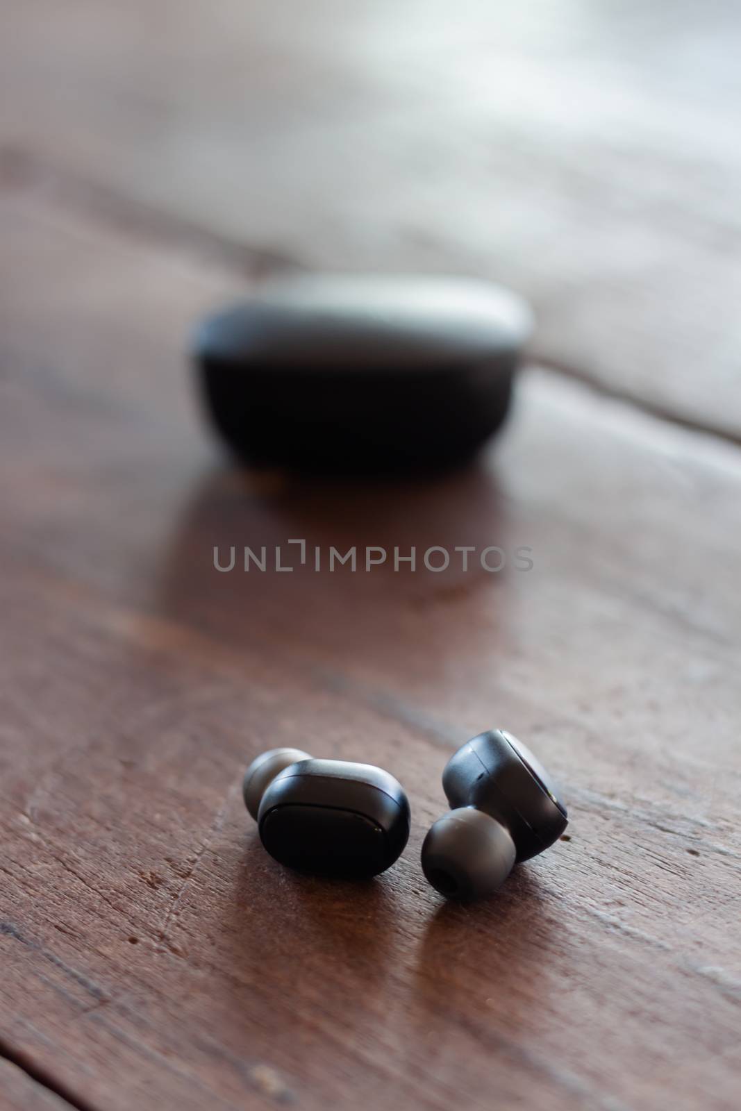 Wireless headphones on wooden background, stock photo