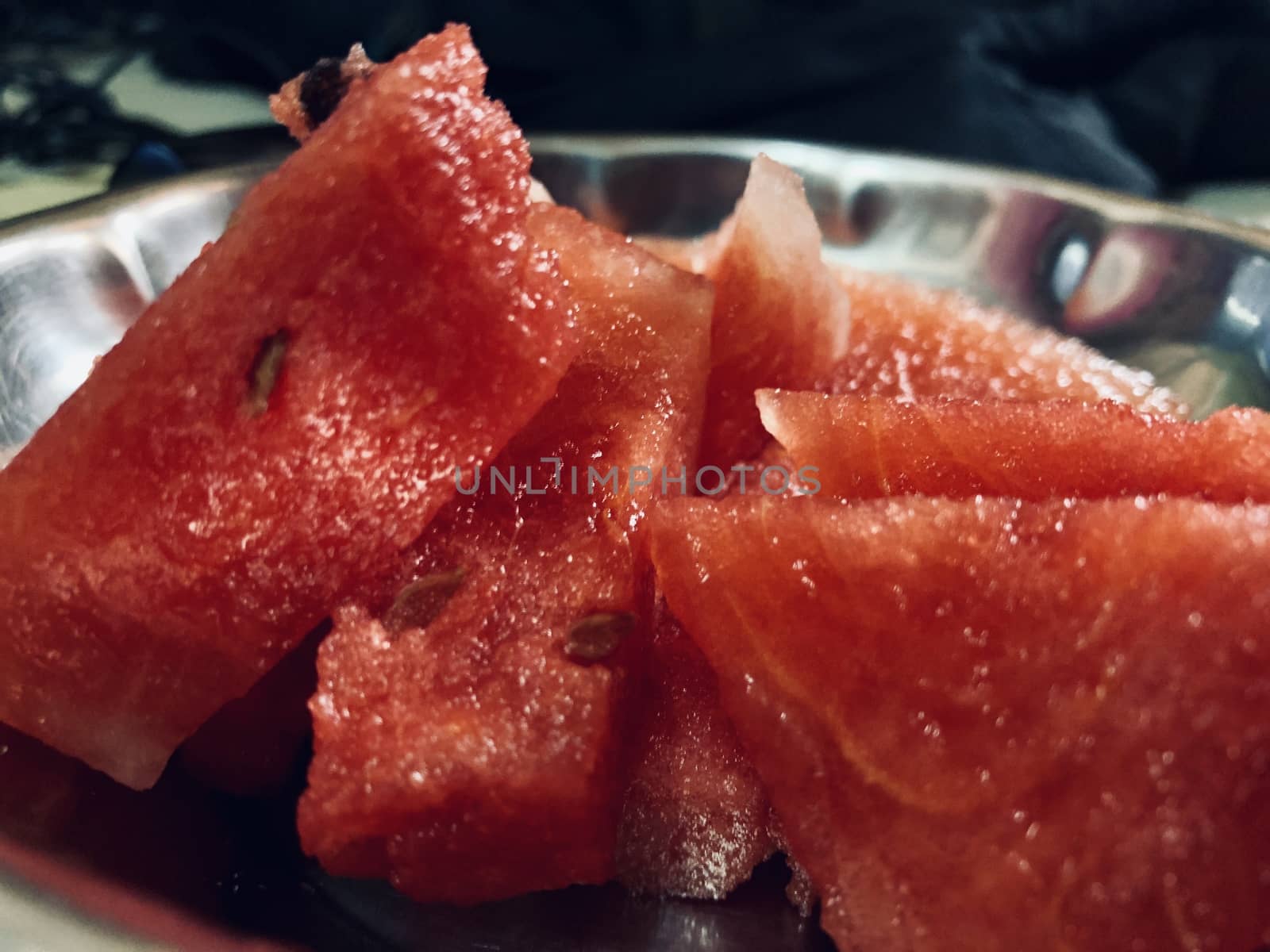 Raw water melons are cut into pieces for serving after lunch