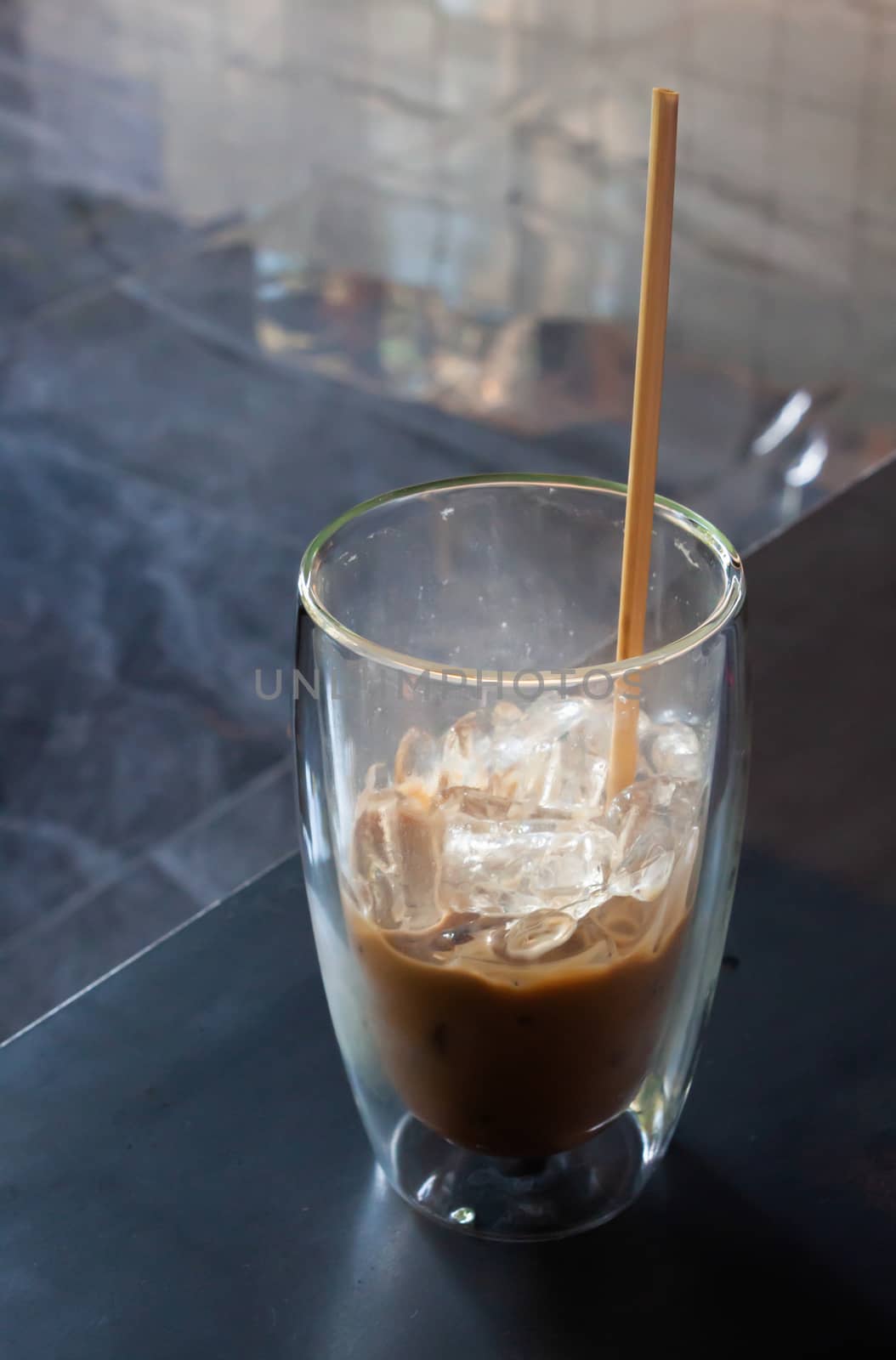 Iced coffee in coffee shop on wooden table, stock photo