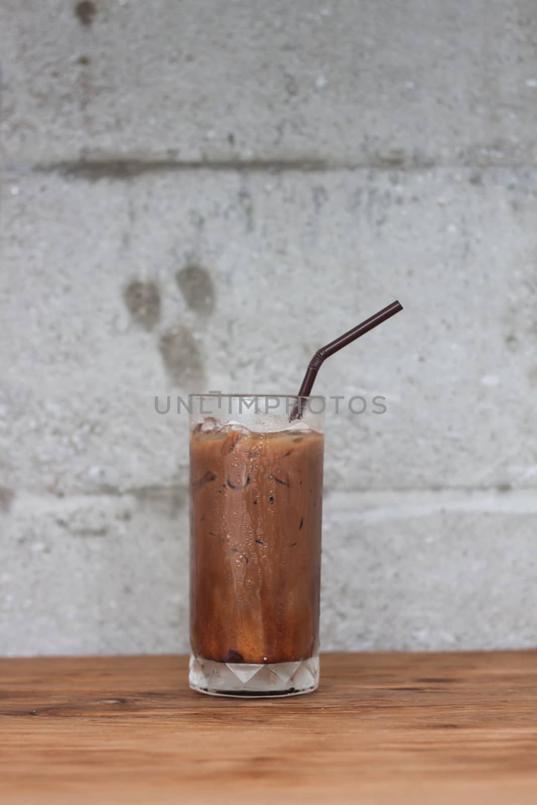 Ice coffee on wooden table by punsayaporn