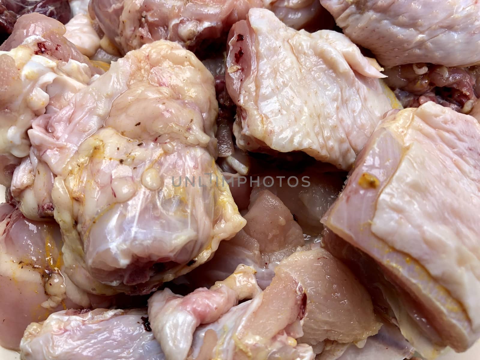 Small pieces of raw chicken meat kept in a plate for cooking