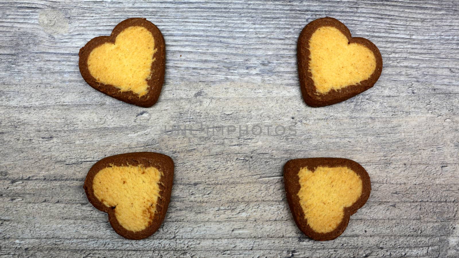 heart-shaped cookies with tea or coffee lie on a wooden table