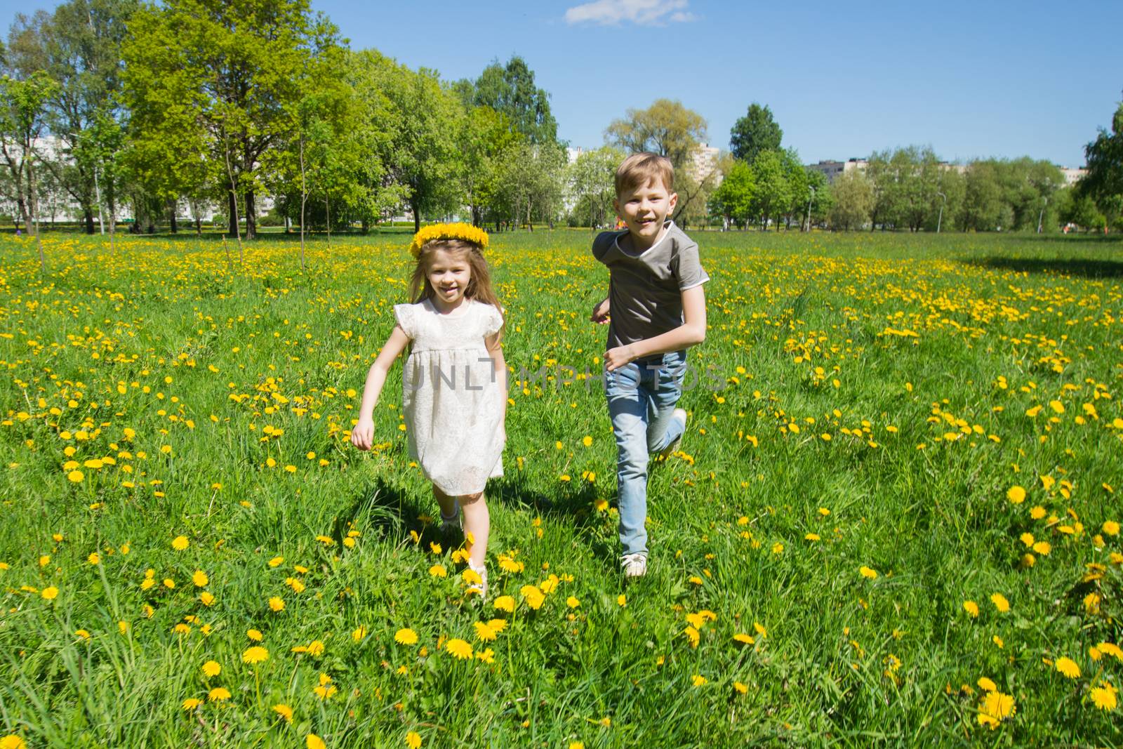 Children running in sunny meadow by Yellowj