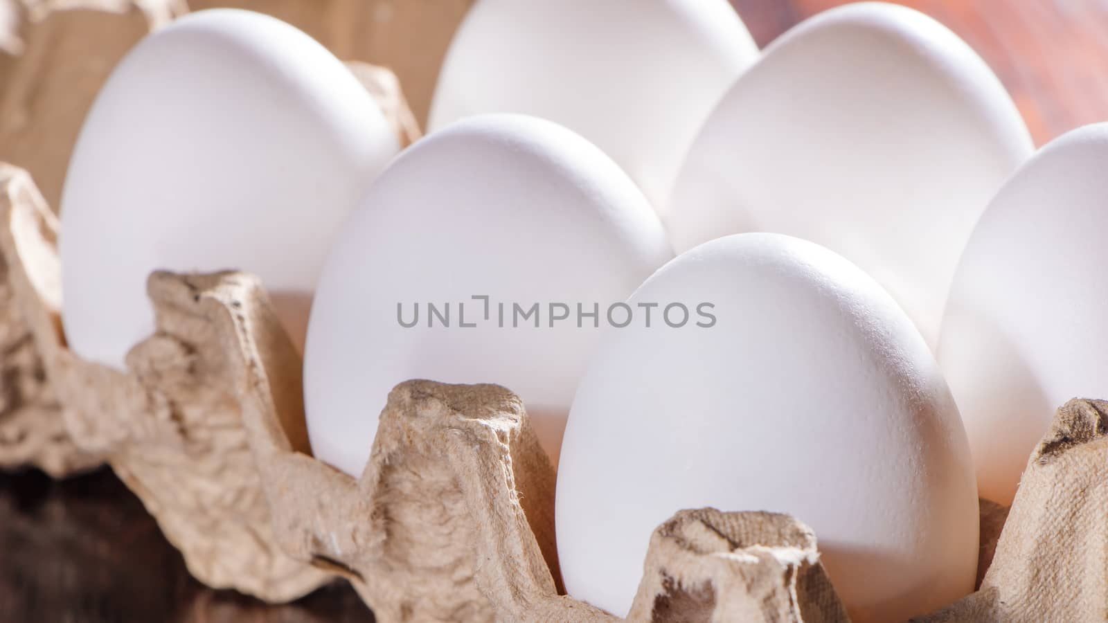 Chicken eggs in the morning sun. Raw eggs in a tray close-up on the kitchen table.