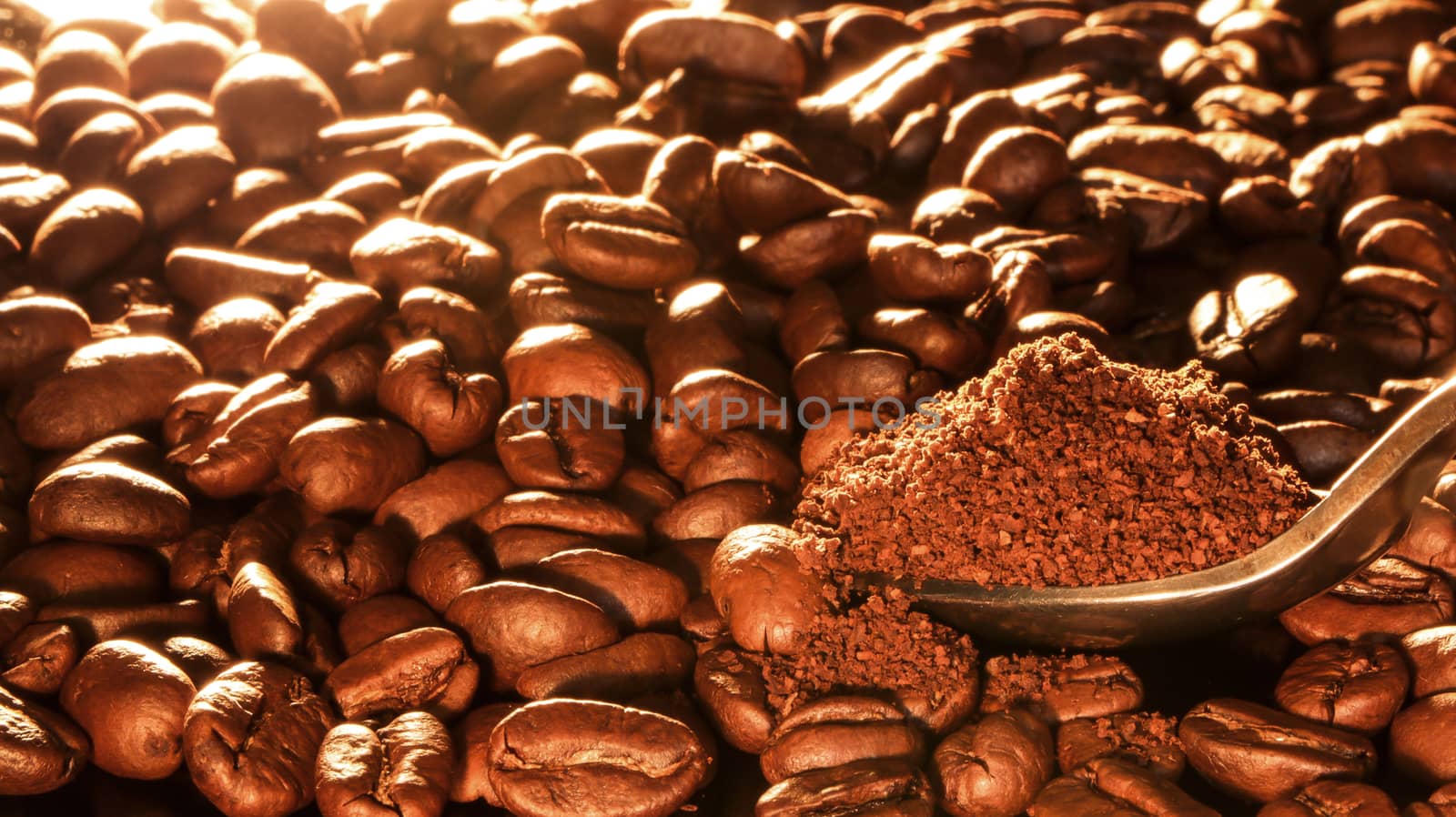 Coffee beans close-up with a spoon of ground coffee. by YevgeniySam