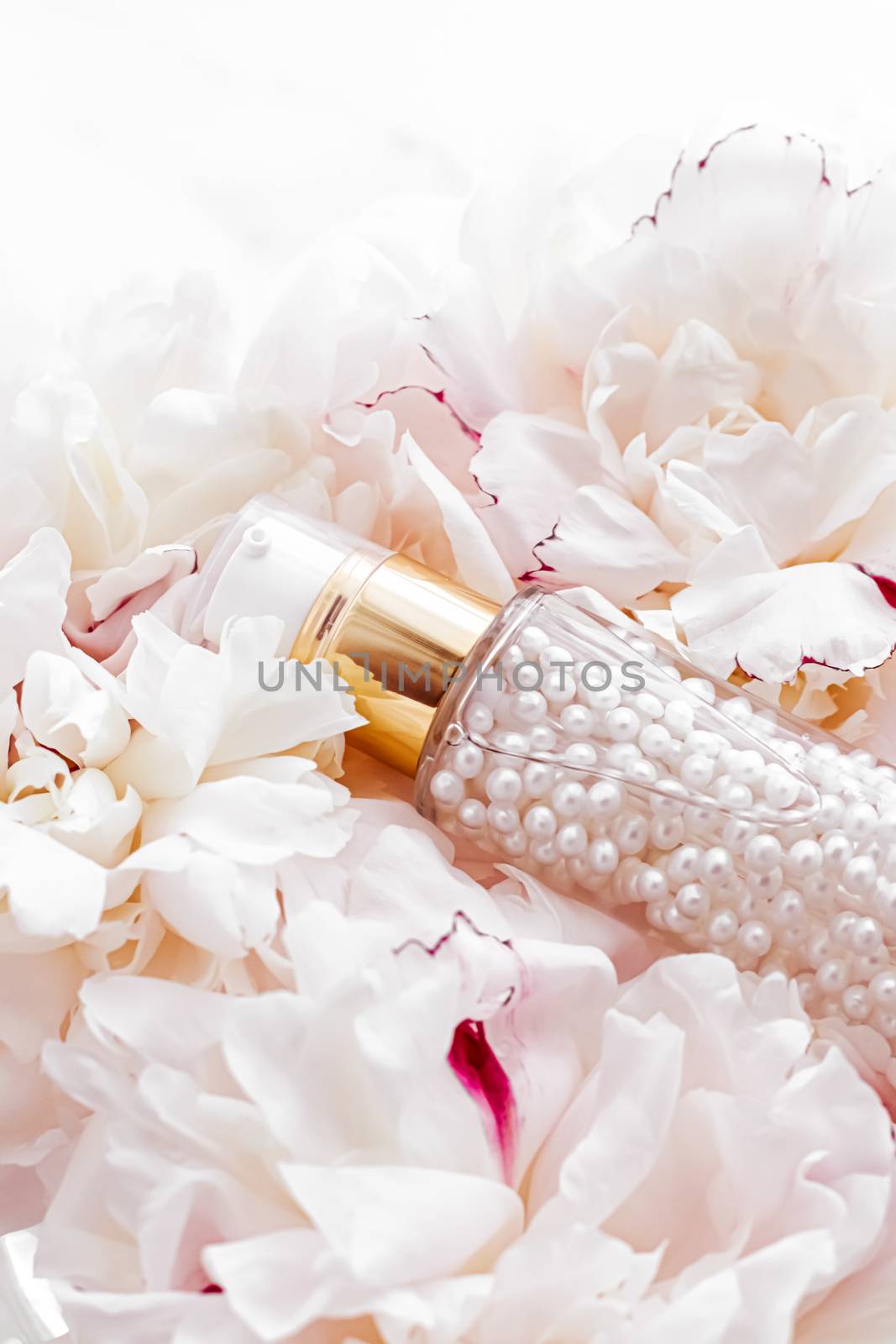 Luxurious cosmetic bottle as antiaging skincare product on background of flowers, blank label packaging for body care branding design