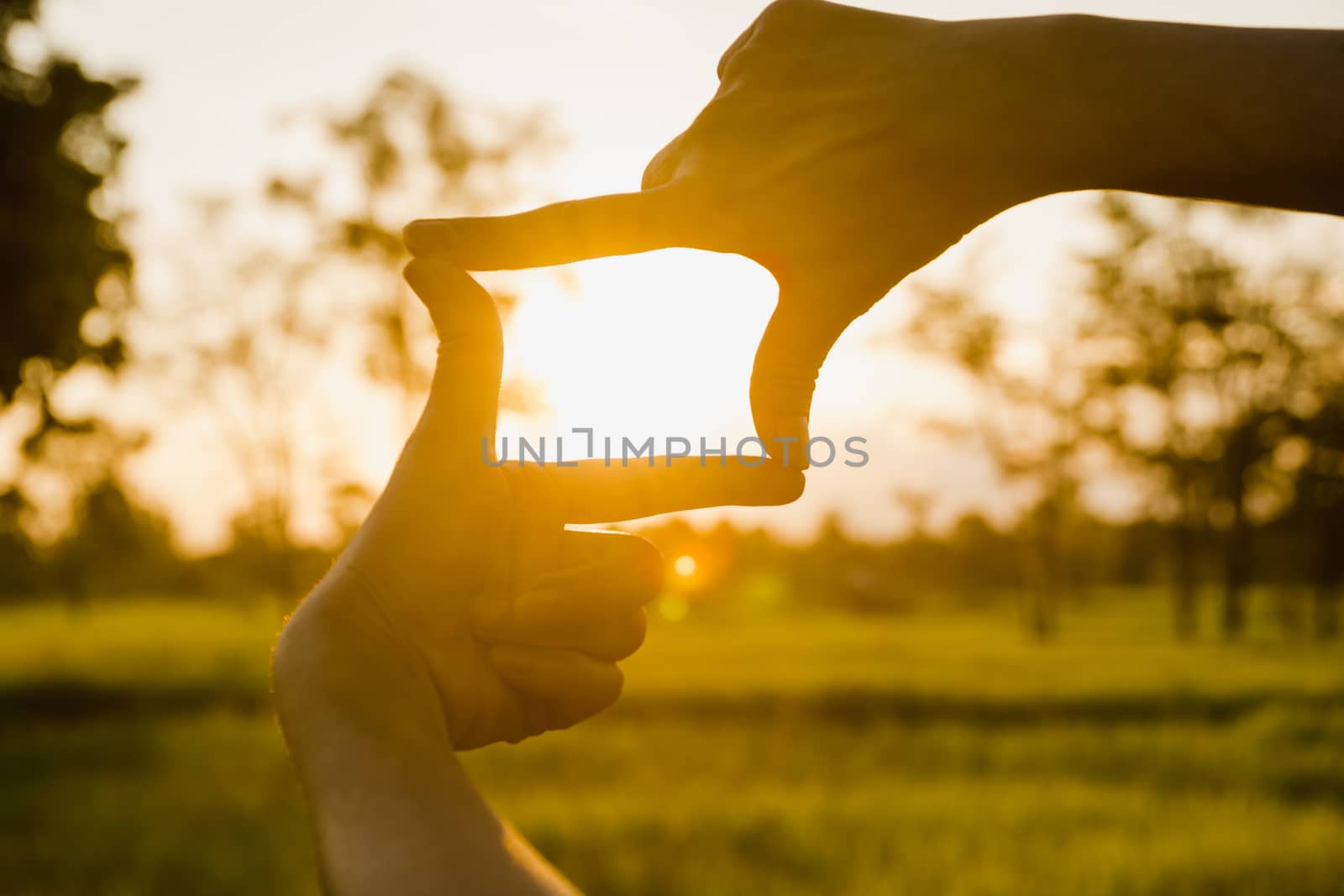 Close up of hands making frame gesture. Close up of woman hands making frame gesture with sunset.