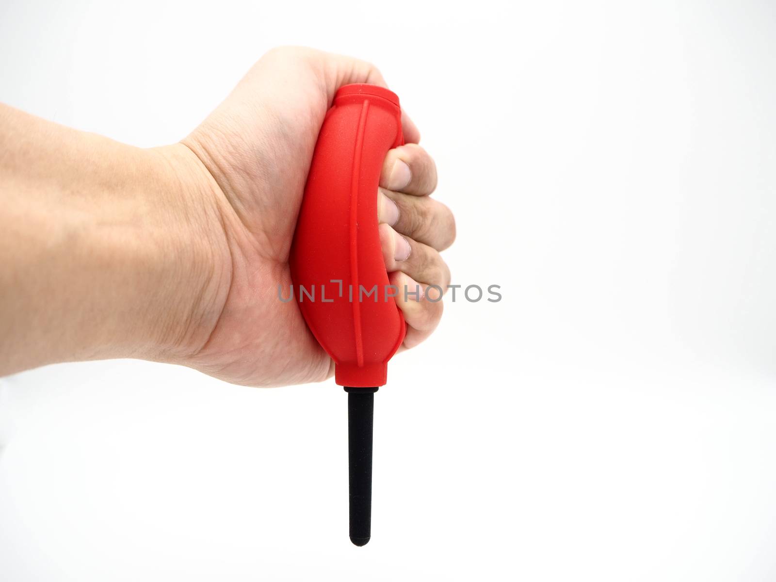 Hand squeezing a red camera air blower isolated on a white background.