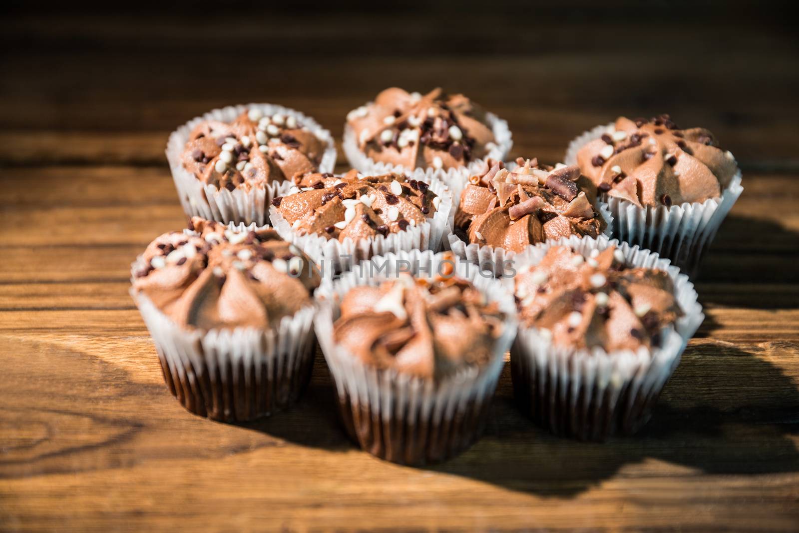 Chocolate cupcakes on a table by Wavebreakmedia