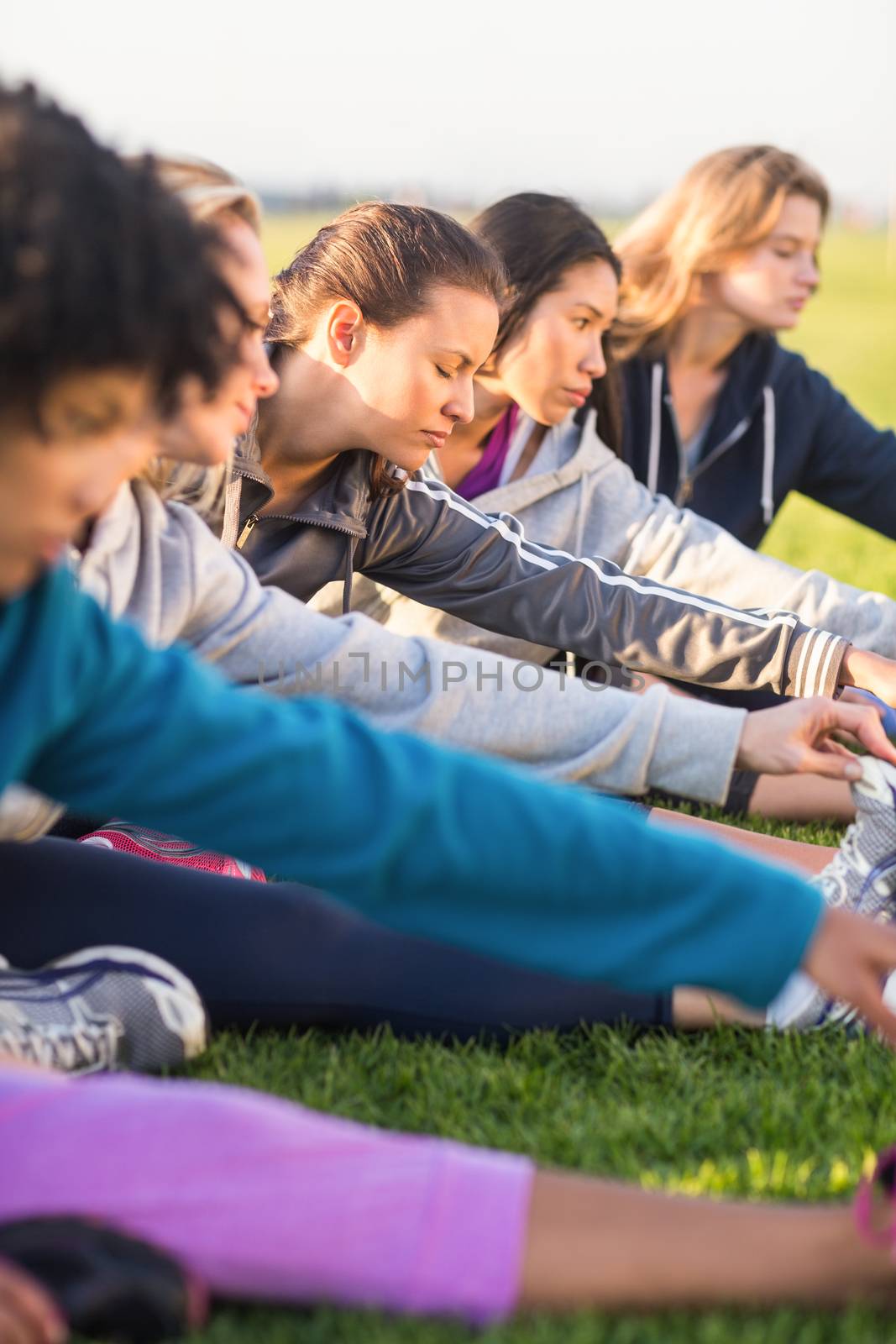 Sporty women stretching during fitness class in parkland
