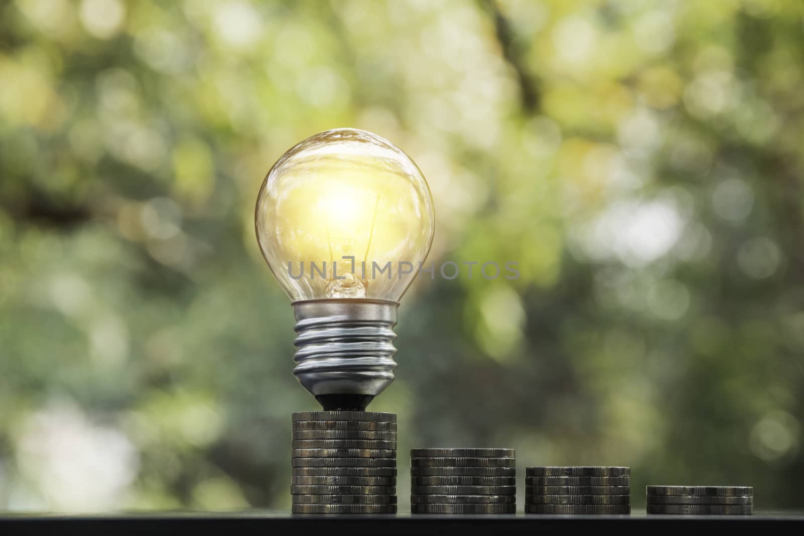 Energy saving light bulb with stacks of coins for saving, financial and accounting concept and copy space for insert text.