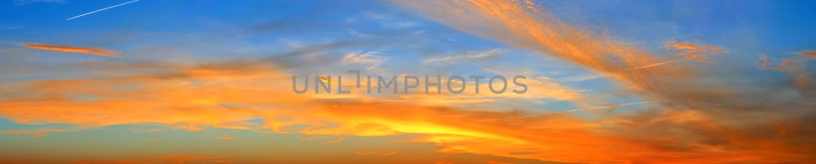 Beautiful high resolution panorama of orange and red sunset clouds in the evening sky.