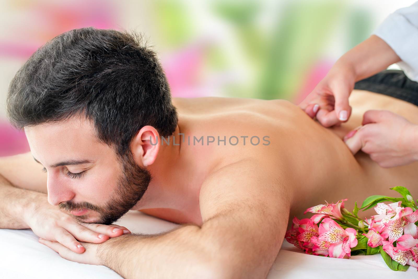 Young man enjoying back massage. by karelnoppe
