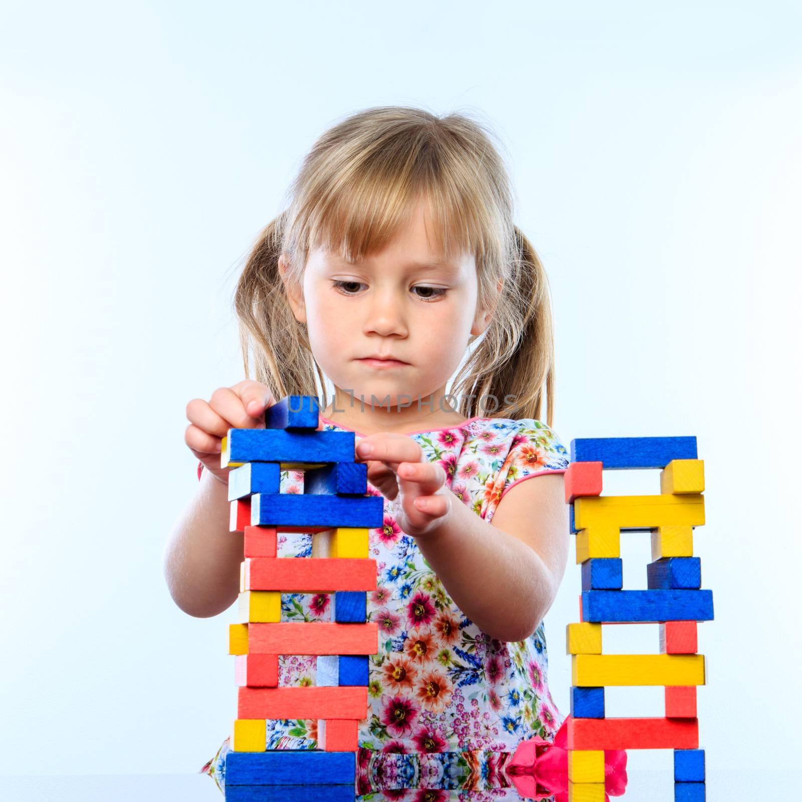 Close up portrait of infant building structure with color wooden blocks.