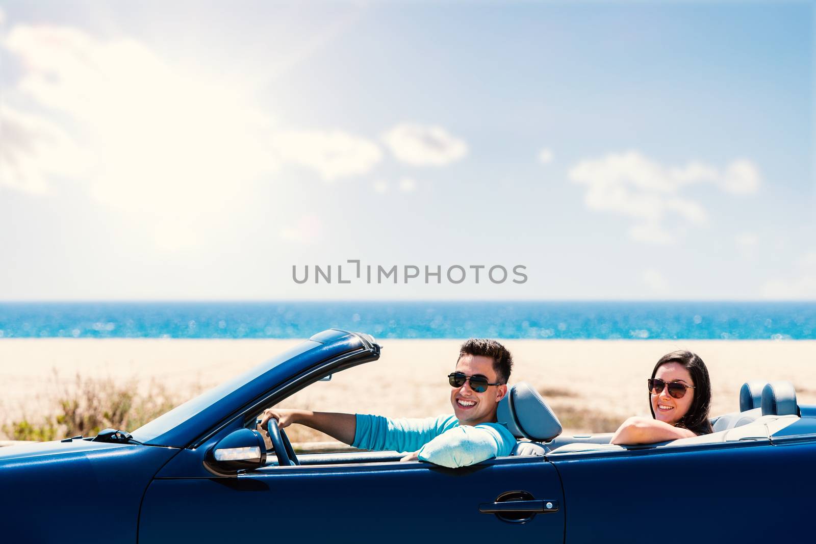 Cute couple driving convertible. by karelnoppe