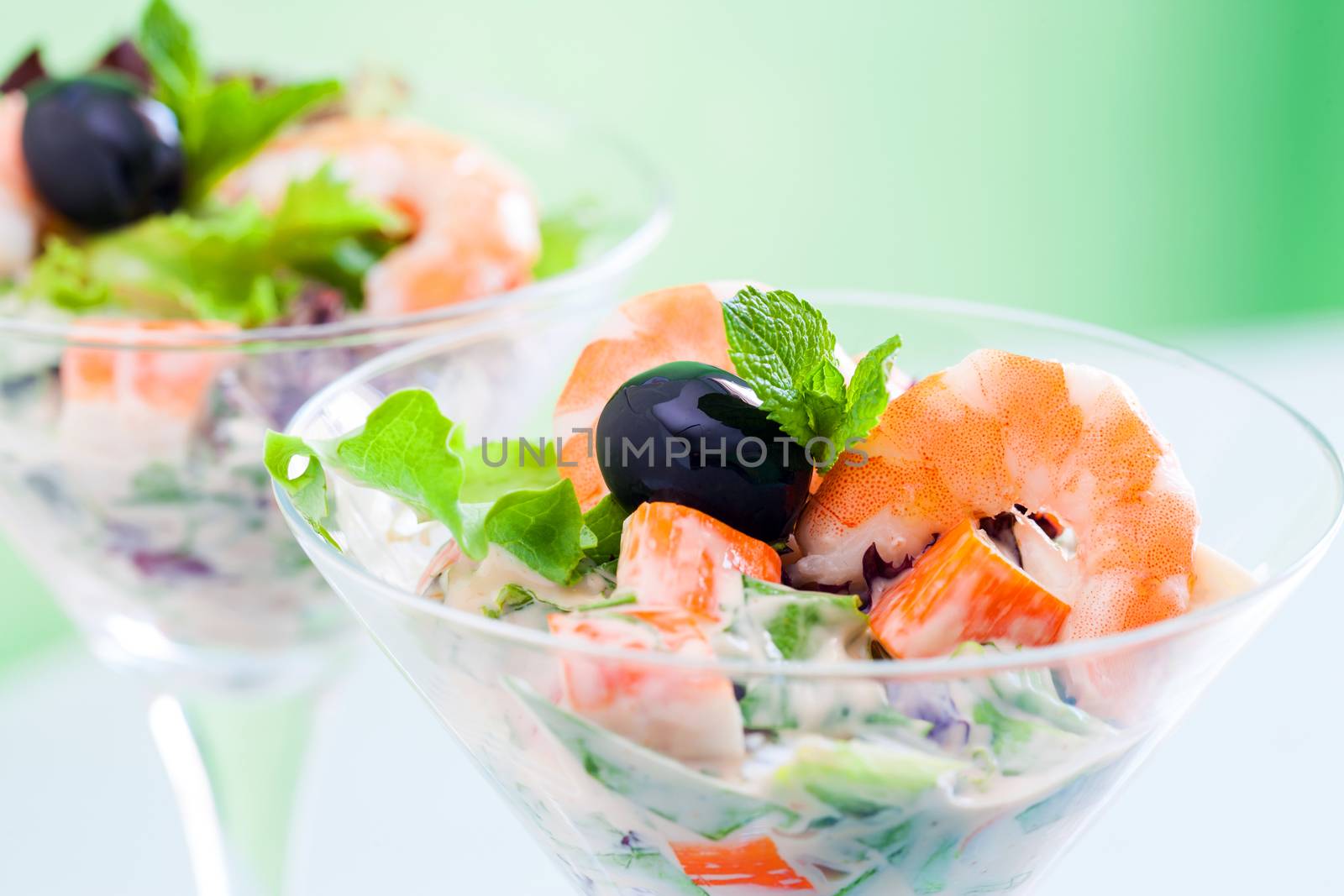 Extreme close up of langoustine and crab cocktail salad served in transparent glasses.