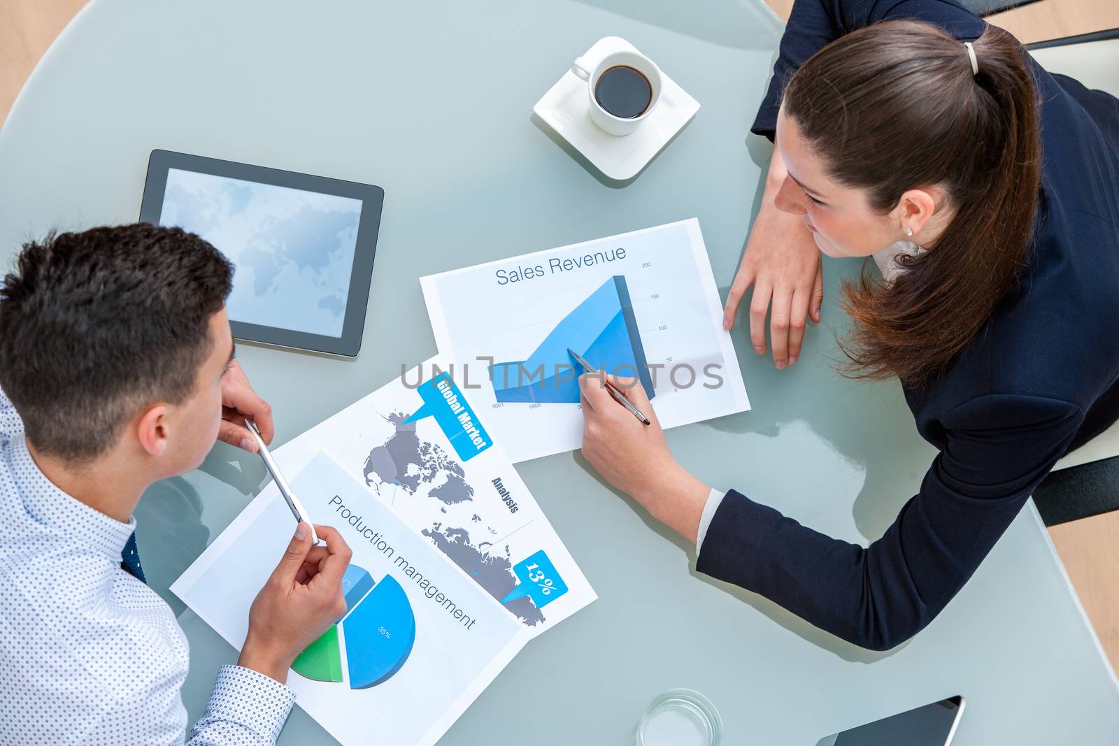 Business partners discussing work together.Top view of young man and woman analyzing documents and statistics at table.