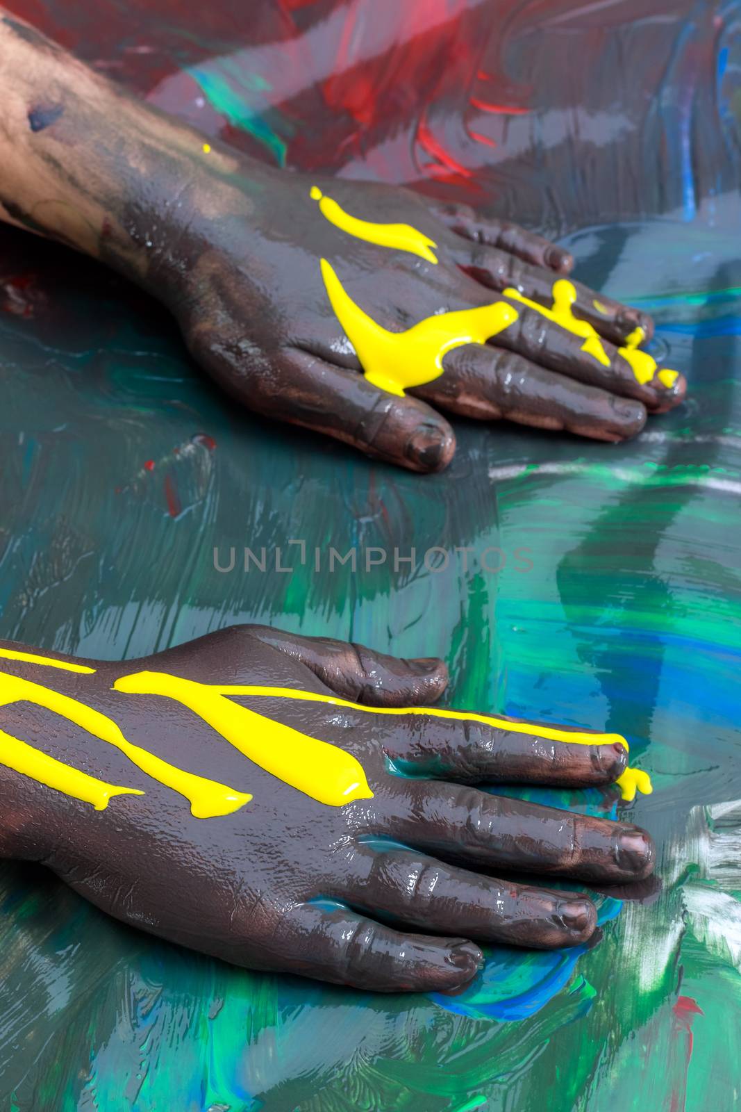 Close up of Infant hands painting and messing with color paint.