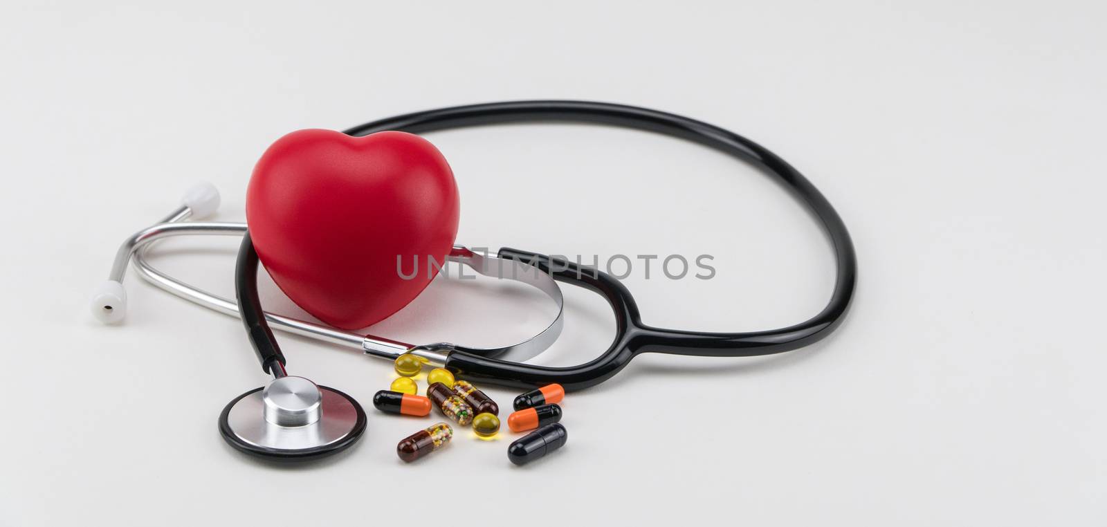 Stethoscope, pills and toy heart. Concept healthcare. Cardiology - care of the heart