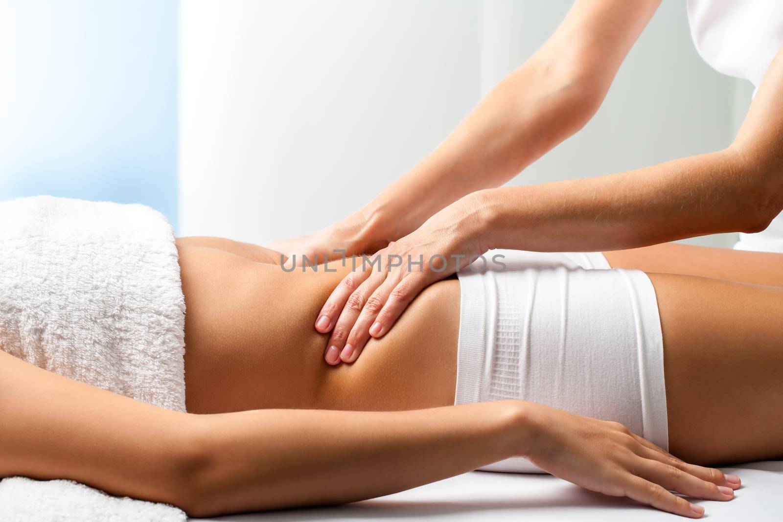 Therapist doing curative belly massage on female patient. by karelnoppe