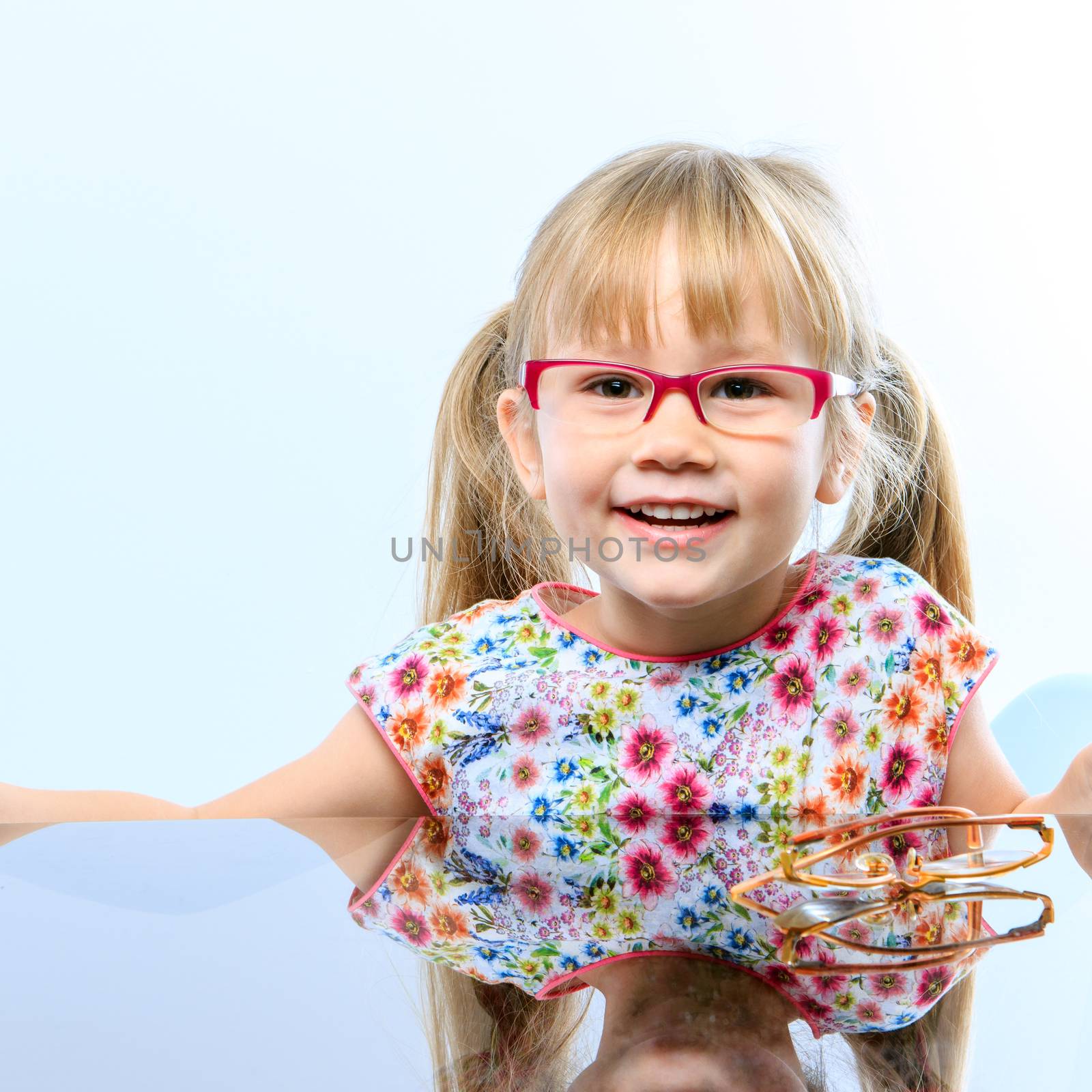 Close up portrait of cute little girl wearing new glasses.