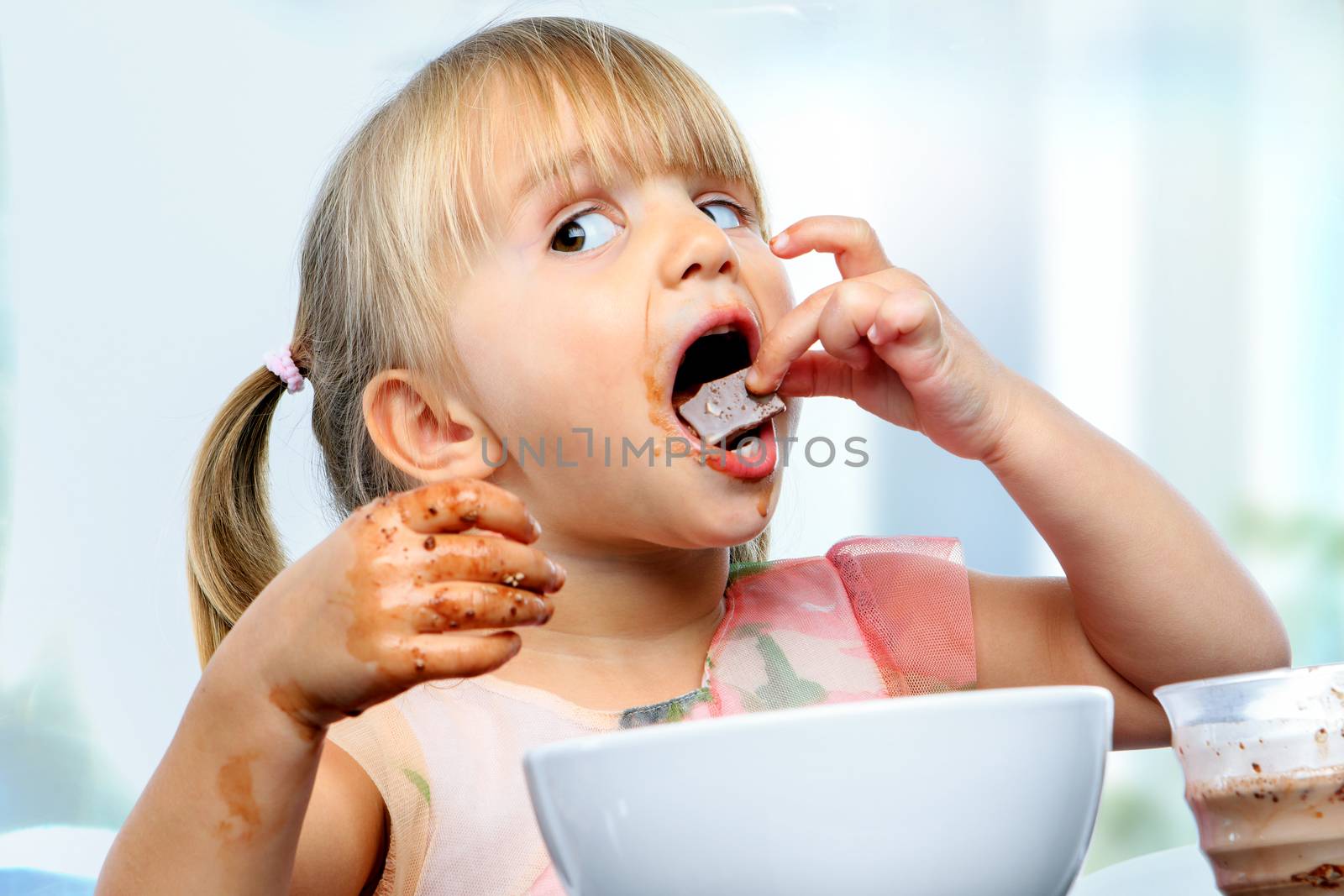 Little girl eating chocolate breakfast. by karelnoppe