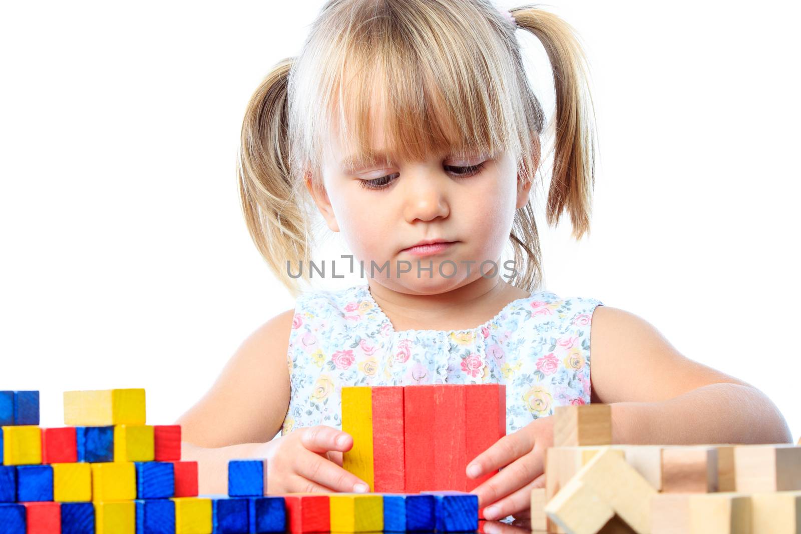 Cute three year old playing with wood blocks. by karelnoppe