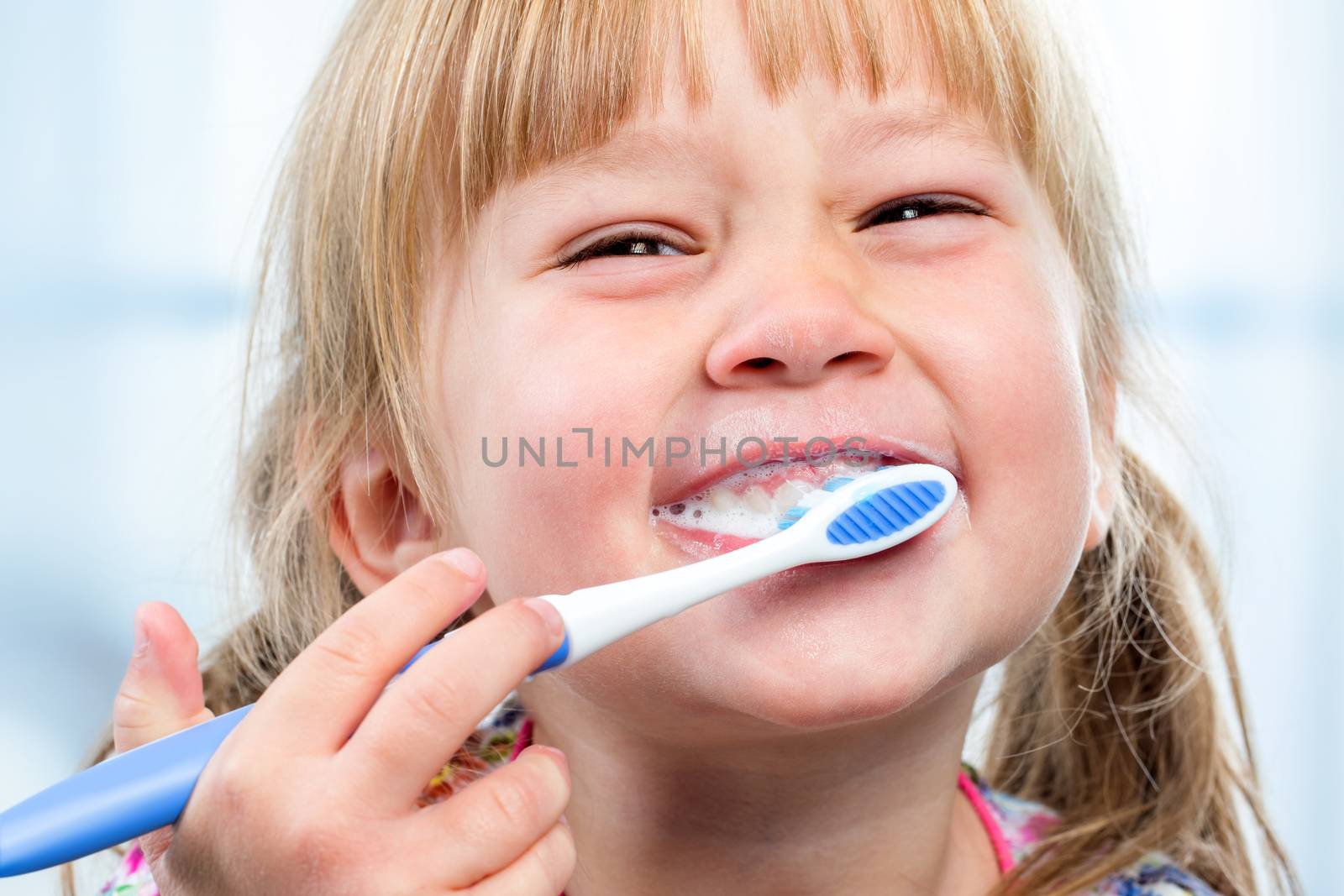 Youngster having fun brushing teeth. by karelnoppe